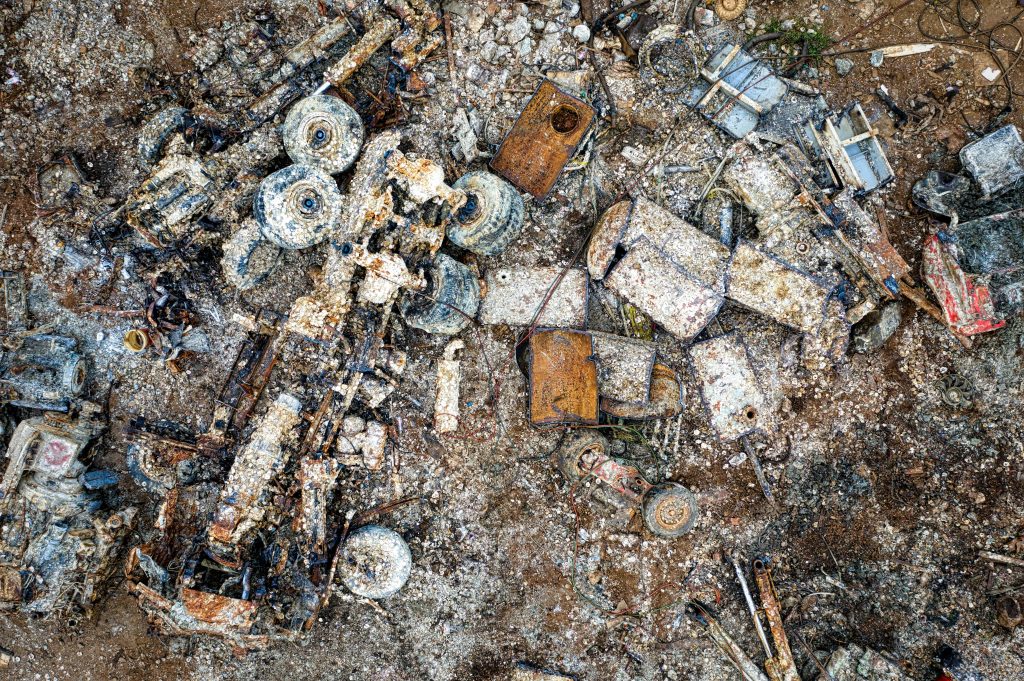 Aerial shot showing a rusted metal junkyard in Jakarta, Indonesia, filled with old vehicles and scrap metal.